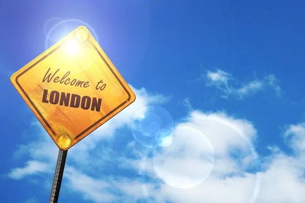 Yellow road sign with a blue sky and white clouds: Welcome to lo — Stock Fotó