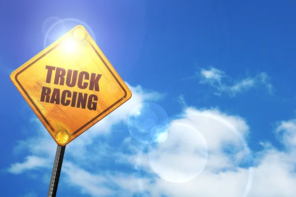 Yellow road sign with a blue sky and white clouds: truck racing — Φωτογραφία Αρχείου