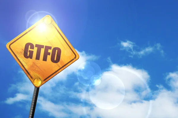 Yellow road sign with a blue sky and white clouds: gtfo internet — Stockfoto