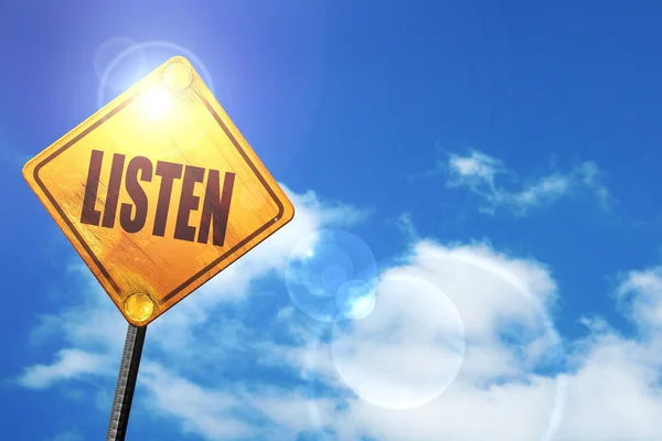 Žlutá dopravní značka s modré nebe a bílé mraky: naslouchat — Stock fotografie