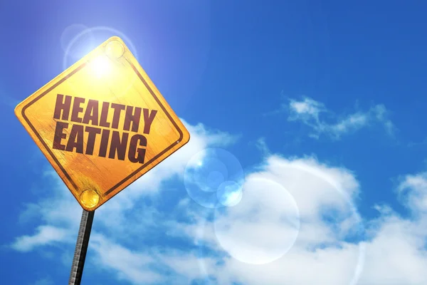 Yellow road sign with a blue sky and white clouds: healthy eatin — Stock Photo, Image