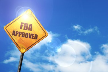 Yellow road sign with a blue sky and white clouds: FDA approved clipart