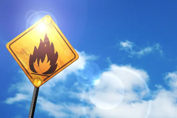 Yellow road sign with a blue sky and white clouds: Flammable haz — Stock fotografie