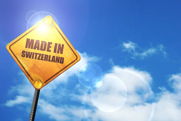 Yellow road sign with a blue sky and white clouds: Made in switz — 图库照片