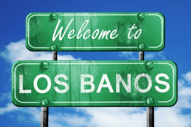los banos vintage green road sign with blue sky background clipart