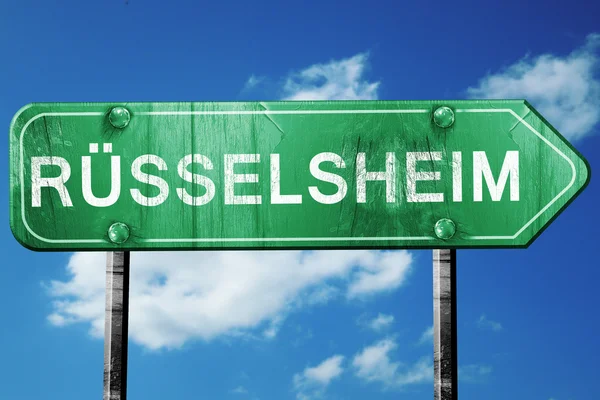 Panneau routier Russelsheim, vert vintage avec fond nuageux — Photo
