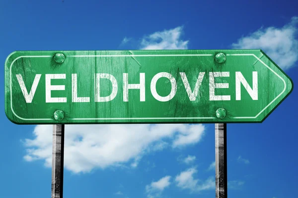 Дорожный знак Veldhoven, винтажный зеленый на фоне облаков — стоковое фото