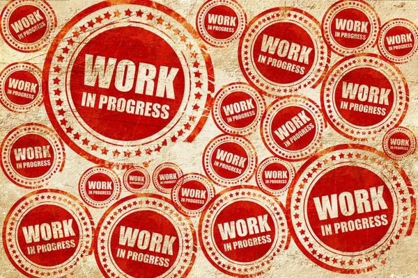 Trabalho em andamento, selo vermelho em uma textura de papel grunge — Fotografia de Stock