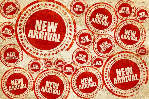 Nieuwe aankomst, rode stempel op een grunge papier textuur — Stockfoto