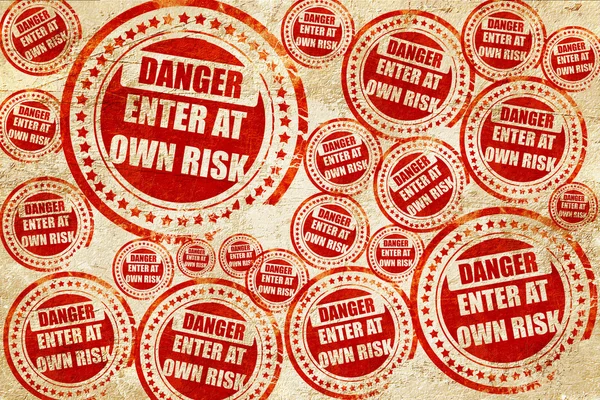 Enter at own risk, red stamp on a grunge paper texture — Stock Photo, Image