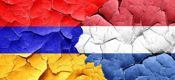 Флаг Армении с флагом Нидерландов на гранжевой треснувшей стене — стоковое фото