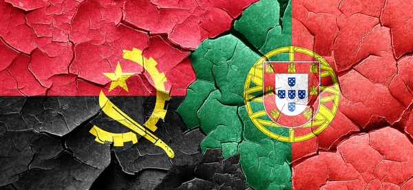 Angola-Flagge mit portugiesischer Flagge an einer Grunge-Risswand — Stockfoto