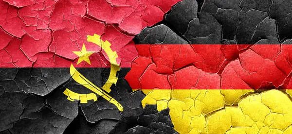 Angola-Fahne mit Deutschland-Fahne an einer Grunge-Risswand — Stockfoto