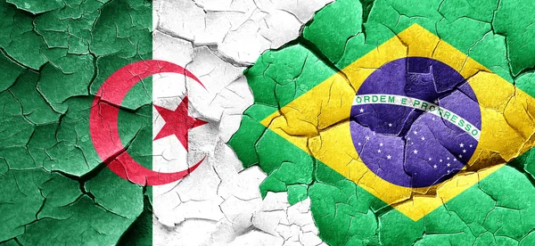 Algerien-Flagge mit brasilianischer Flagge an einer Grunge-Risswand — Stockfoto