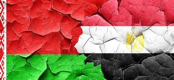 Belarus flag with egypt flag on a grunge cracked wall