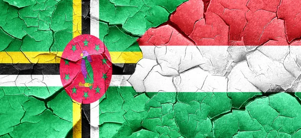 Dominica flag with Hungary flag on a grunge cracked wall