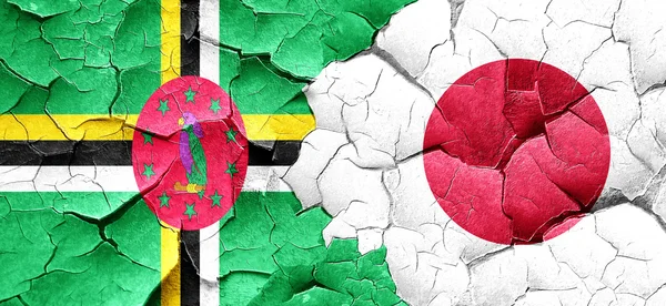 Dominica flag with Japan flag on a grunge cracked wall