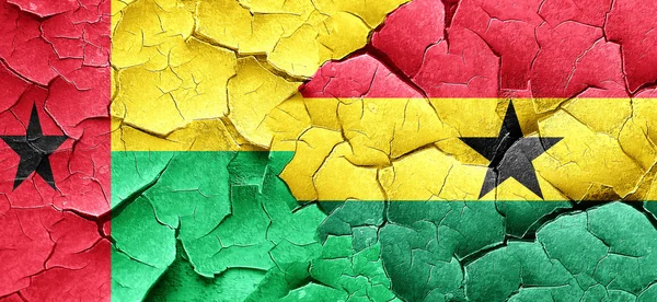 Guinea-Bissau-Flagge mit Ghanafahne an einer Grunge-Risswand — Stockfoto