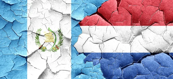guatemala flag with Netherlands flag on a grunge cracked wall