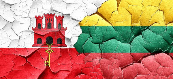 gibraltar flag with Lithuania flag on a grunge cracked wall