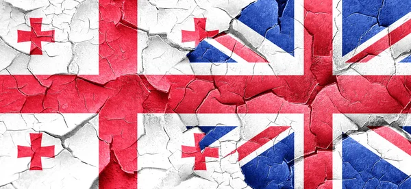 Georgia flag with Great Britain flag on a grunge cracked wall — Stock Photo, Image