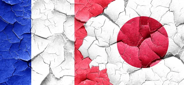Frankrike flagga med Japan flagga på en grunge knäckt vägg — Stockfoto
