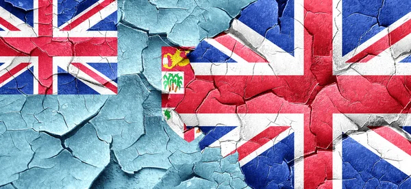 Fiji flag with Great Britain flag on a grunge cracked wall
