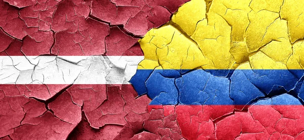 Lotyšsko vlajka Kolumbie vlajka na grunge popraskané zdi — Stock fotografie