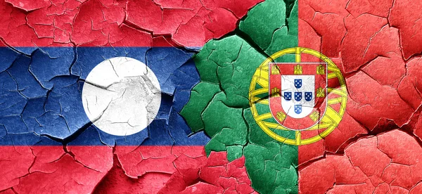 Vlag van Laos met Portugal vlag op een grunge gebarsten muur — Stockfoto