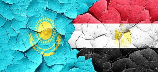 Kazakhstan flag with egypt flag on a grunge cracked wall