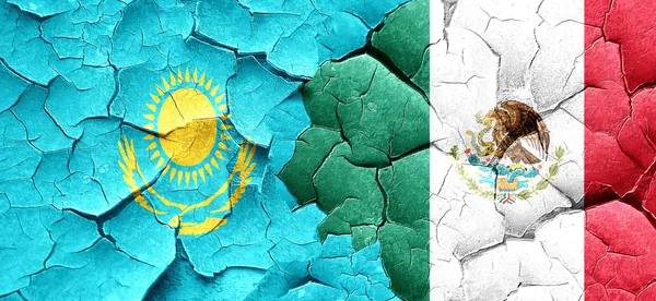 Kazakhstan flag with Mexico flag on a grunge cracked wall