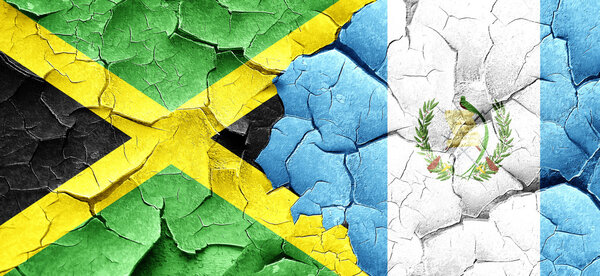 Jamaica flag with Guatemala flag on a grunge cracked wall