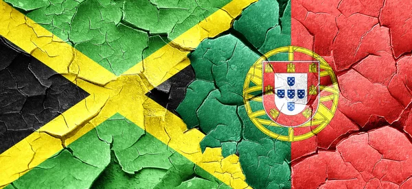 Jamaica vlag met Portugal vlag op een grunge gebarsten muur — Stockfoto