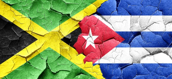 Флаг Ямайки с кубинским флагом на огромной треснувшей стене — стоковое фото