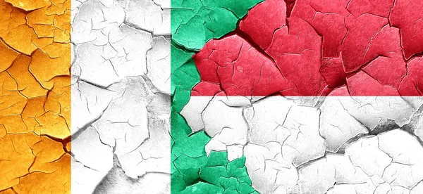 Ivory coast flag with Indonesia flag on a grunge cracked wall