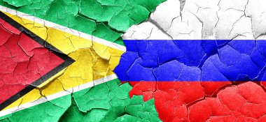 Guyana bayrak bir grunge Rusya bayrağı ile duvar kırık