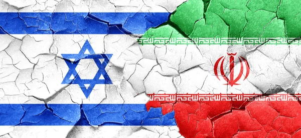 Israel flag with Iran flag on a grunge cracked wall