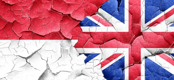 Indonesia flag with Great Britain flag on a grunge cracked wall — Stock Photo, Image