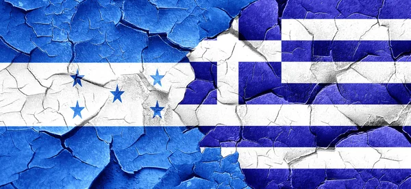 Флаг Гондураса с греческим флагом на огромной треснувшей стене — стоковое фото