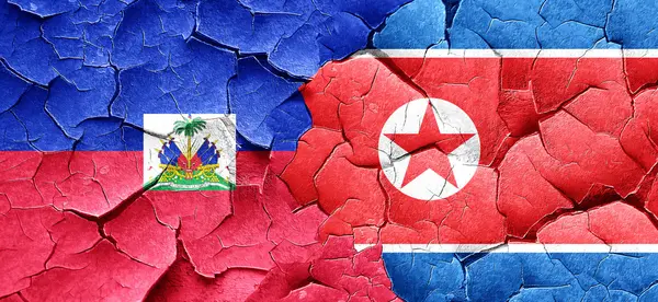 Bandera de Haití con bandera de Corea del Norte en una pared agrietada grunge —  Fotos de Stock