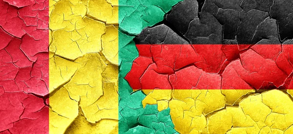 Guinea vlajky s vlajkou Německa na grunge popraskané zdi — Stock fotografie