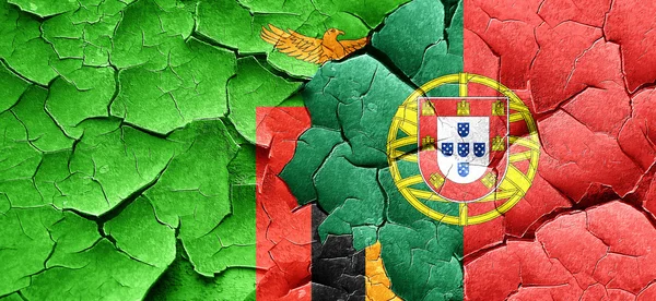 Sambia-Flagge mit portugiesischer Flagge an einer Grunge-Risswand — Stockfoto