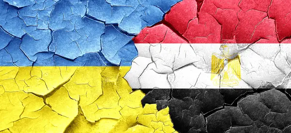 Флаг Украины с египетским флагом на гранжевой треснувшей стене — стоковое фото