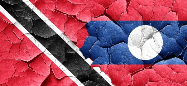 Trinidad and tobago flag with Laos flag on a grunge cracked wall — Stock Photo, Image