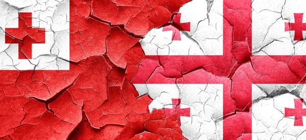 Tonga flag with Georgia flag on a grunge cracked wall