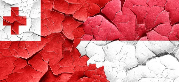 Tonga flag with Indonesia flag on a grunge cracked wall