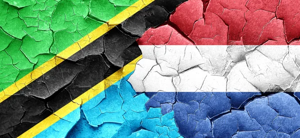 Tanzanian flag with Netherlands flag on a grunge cracked wall
