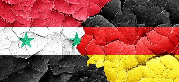 Syrien flagga med Tyskland flagga på en grunge knäckt vägg — Stockfoto