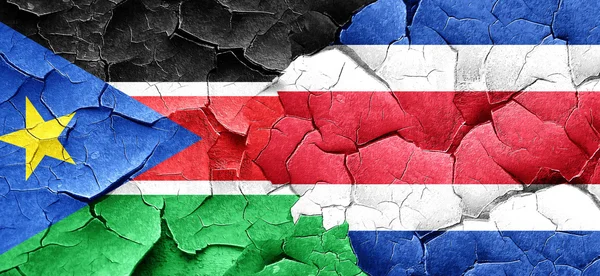 Jižní Súdán vlajky s vlajkou Kostariky na grunge popraskané zdi — Stock fotografie