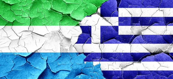 Флаг Сьерра-Леоне с греческим флагом на огромной треснувшей стене — стоковое фото